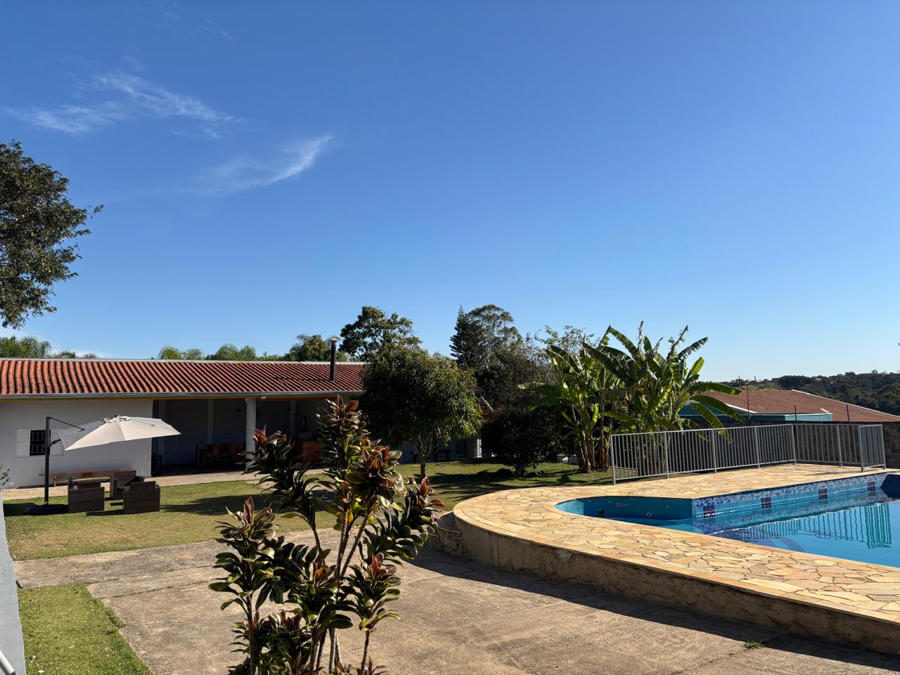 Piscina, gramado e casa da Chácara Leal