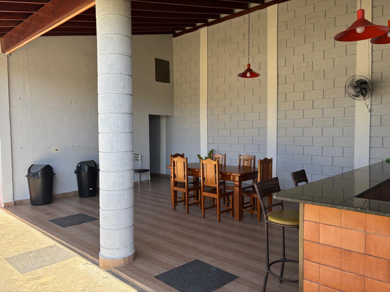 Varanda coberta com mesas e balcão